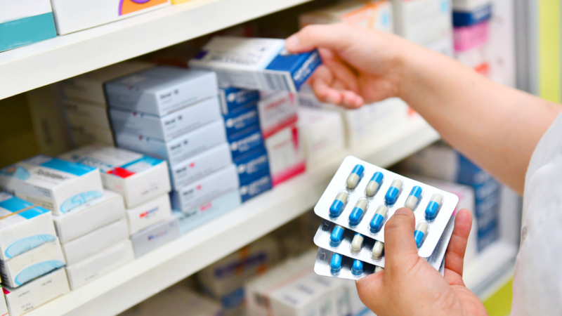 Pharmacist,Holding,Medicine,Box,And,Capsule,Pack,In,Pharmacy,Drugstore.