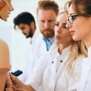 Students,Of,Medicine,Examining,Anatomical,Model,In,Classroom
