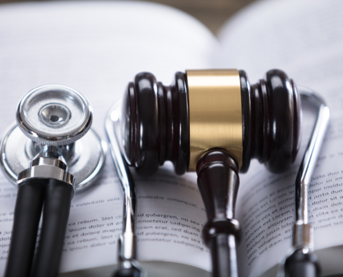 Close-up,Of,Stethoscope,And,Gavel,On,Open,Law,Book